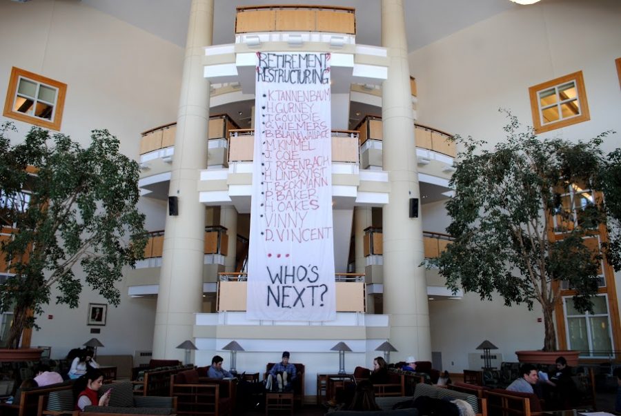 A banner protesting the recent changes in staff and administration hangs inside the Perry Atrium in Pettingill Hall