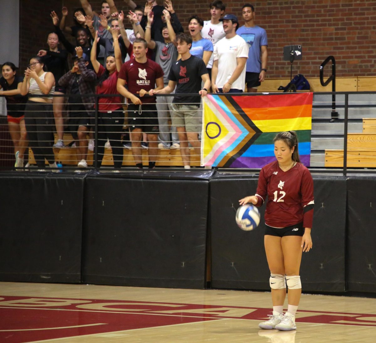 Sami Kim '28 prepares to serve during voleyball's Pride Night match versus Tufts University.