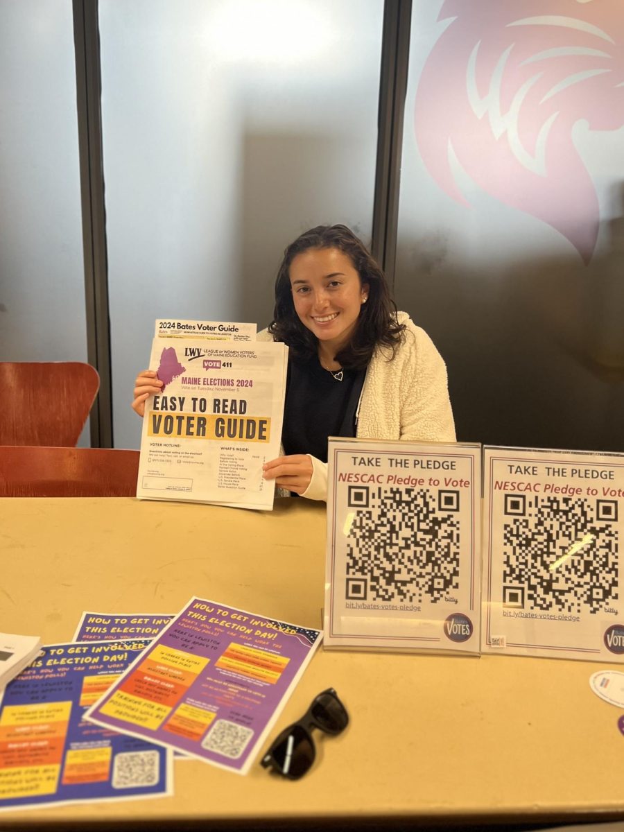 Ava Steinberger '27, helping prospective voters at the Bates Votes information table outside commons.