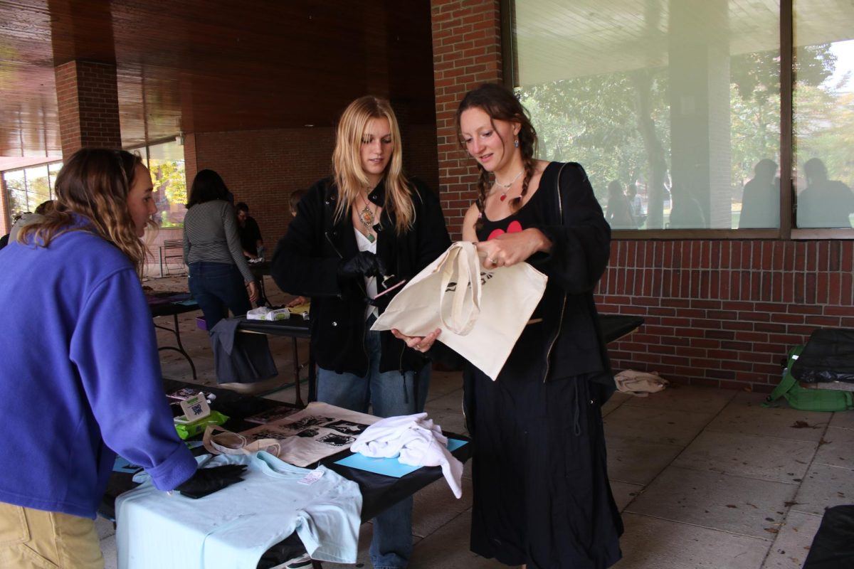 Audrey Cole '26 shows her printed tote bag to Lily Miller '25 and Inez Johnson '25