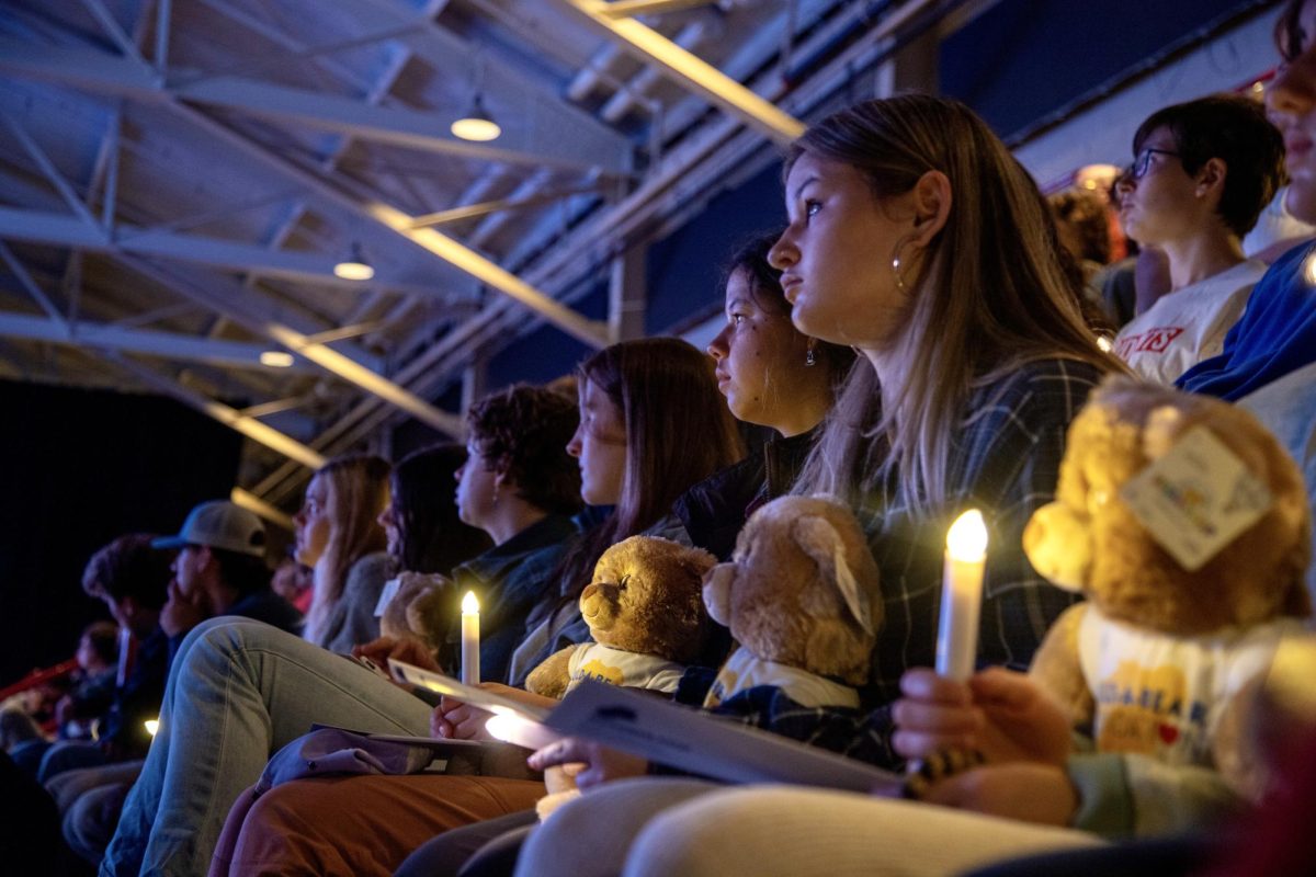 Bates students watch a slideshow of images from the recovery process from the Oct. 25, 2023 Lewiston shootings. About a hundred Bates students attended the anniversary memorial event. 