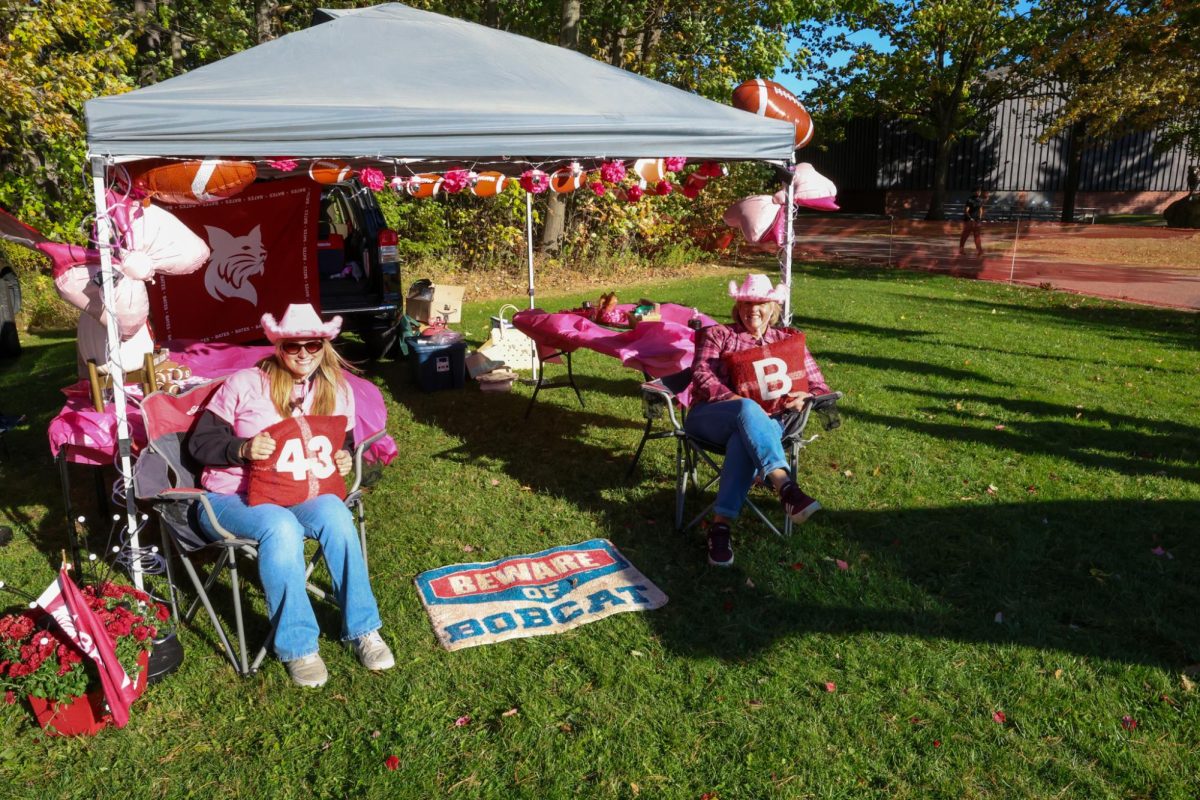 Relatives of Ben Conrad '24 including sister Chase Conrad '26 seated at their tailgate setup before the Bates V. Tufts football game.