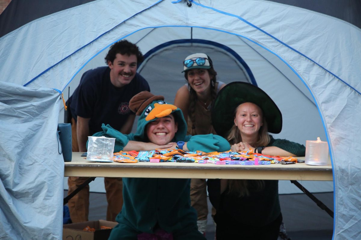 Members of the Bates Outing Club pose in their "Halloween Tent" ready to greet children. 