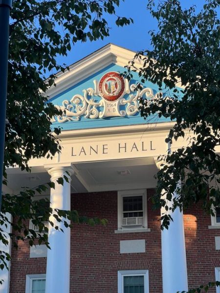 Lane Hall, the college administrative building where the Bates financial offices are, illuminated by the sun on Alumni Walk.