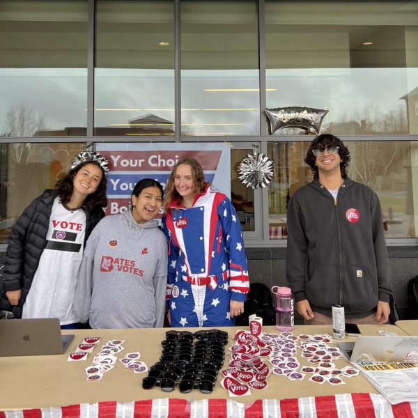 Bates Votes club members table outside of commons answering relevant questions and passing out voter guides, stickers, candy and sunglasses. 