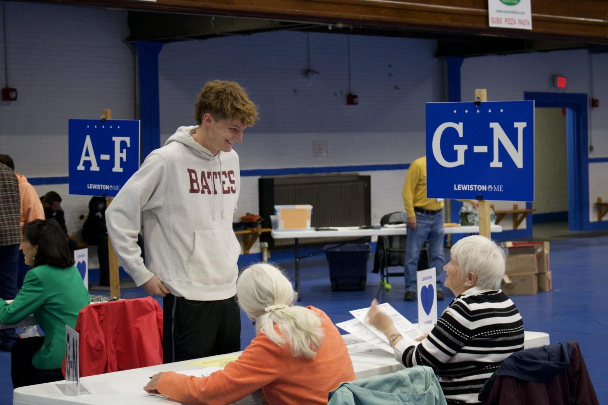 A Bates student laughs with a poll worker at the Lewiston Armory. Bates students were among the roughly 830,000 Mainers who voted on issues at all levels.