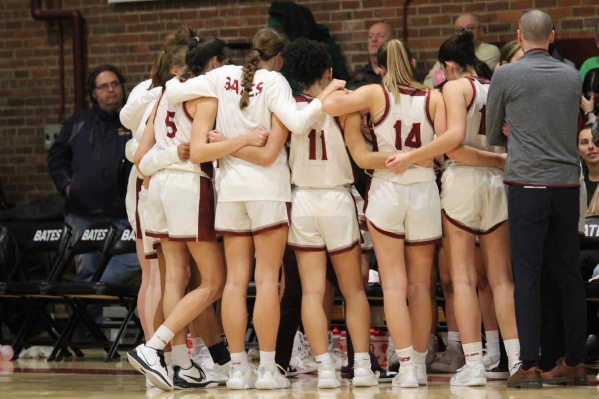 The Bates' Women's basketball team gathers in a group huddle during a time-out in their game against Bowdoin.