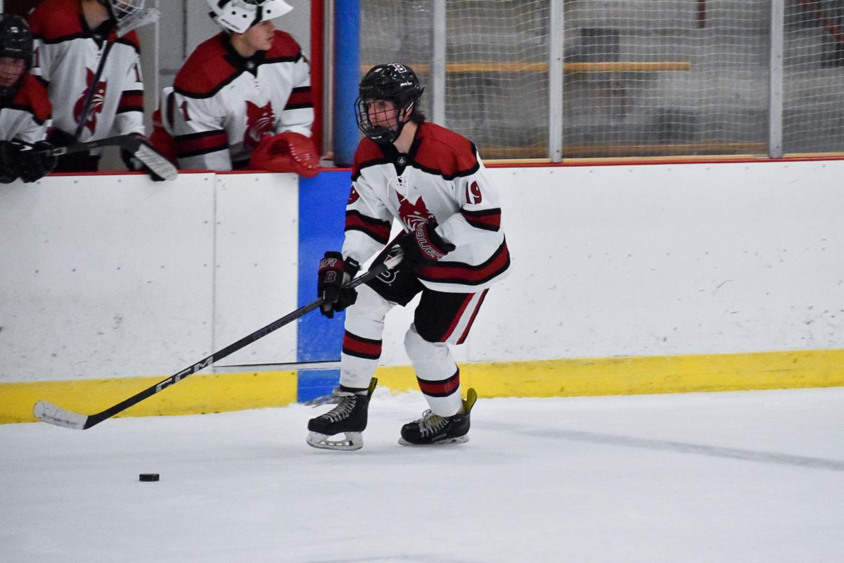 Drew Sondey '27 carrying the puck through the neutral zone during the Bates vs. Dartmouth game at Underhill Arena