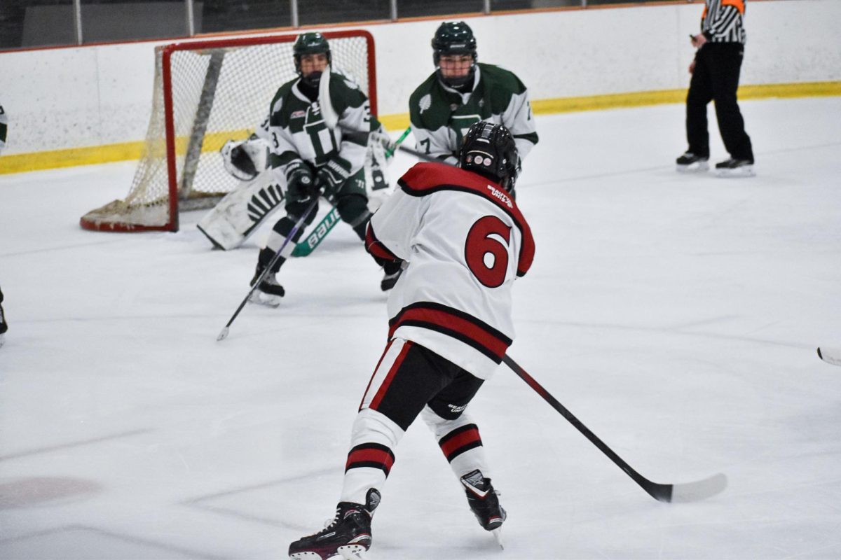 Ryan Somchanhmavong '26 shooting the puck during the Bates vs. Dartmouth game.