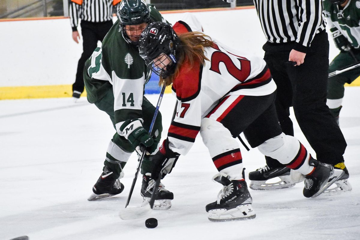 Bradley Wentworth '28 winning the face-off draw at center ice against Dartmouth.