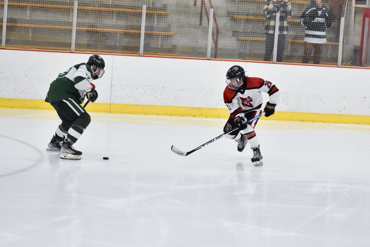 Charlie Kohn '27 creatively moving the puck past the Dartmouth player.