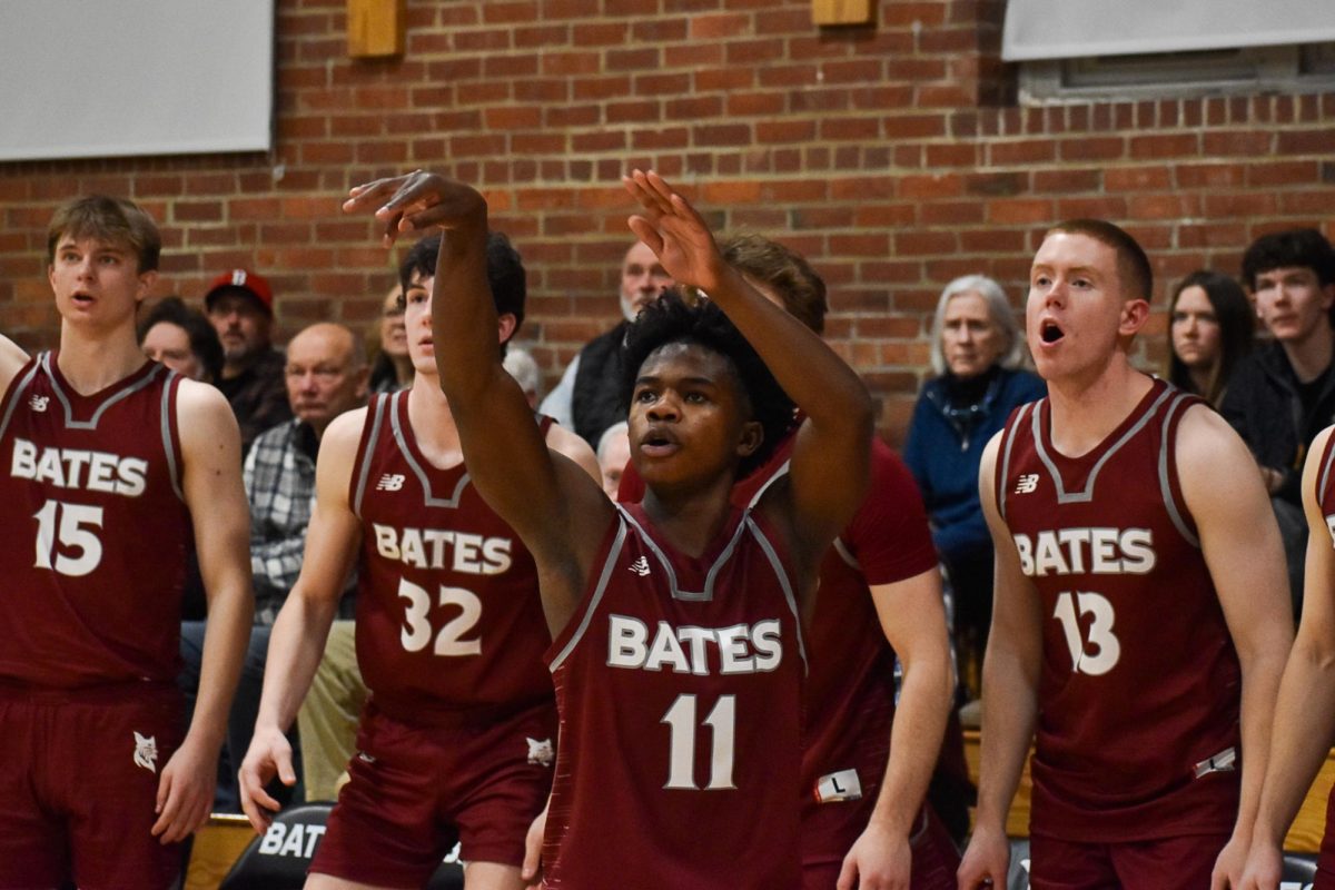 David Omasombo '26 shooting a three pointer during the Bates vs. Wesleyan Men's Basketball game at Alumni Gym.