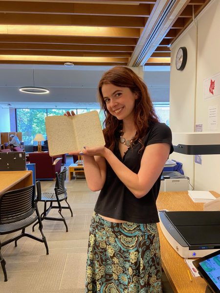 Megan Billings '26 poses with Ina Parsons' diary in Ladd Library.
