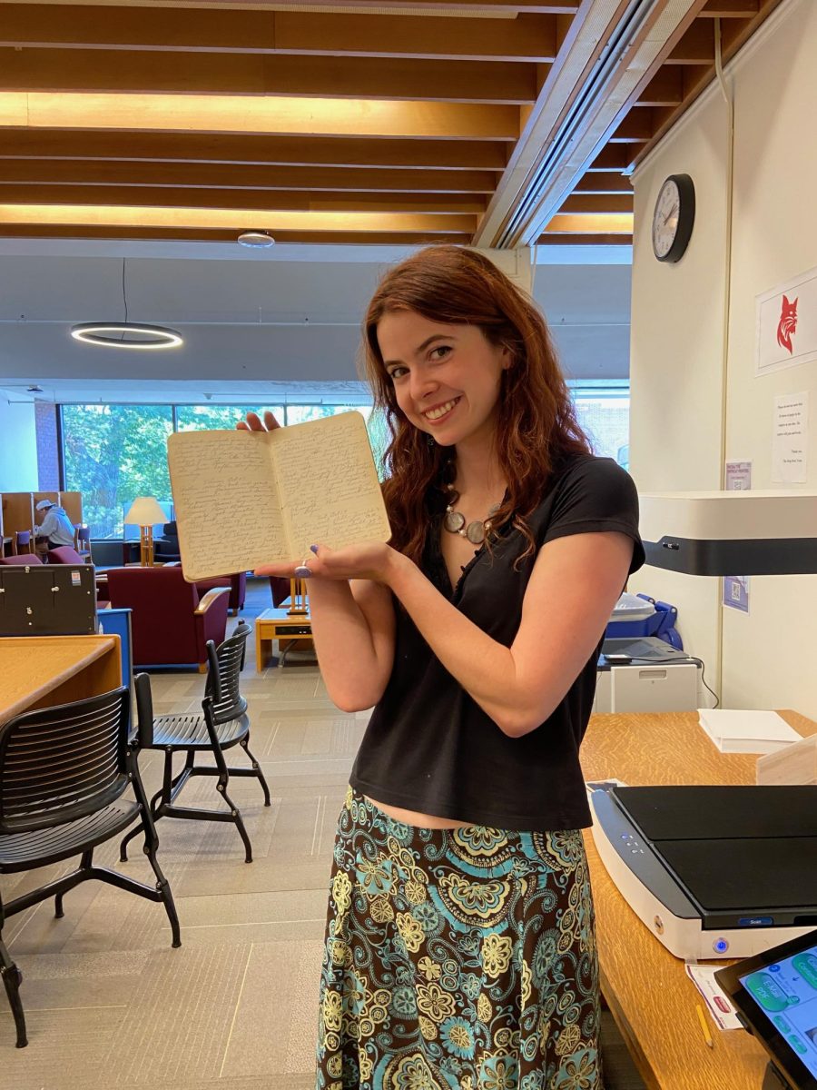 Megan Billings '26 poses with Ina Parsons' diary in Ladd Library.