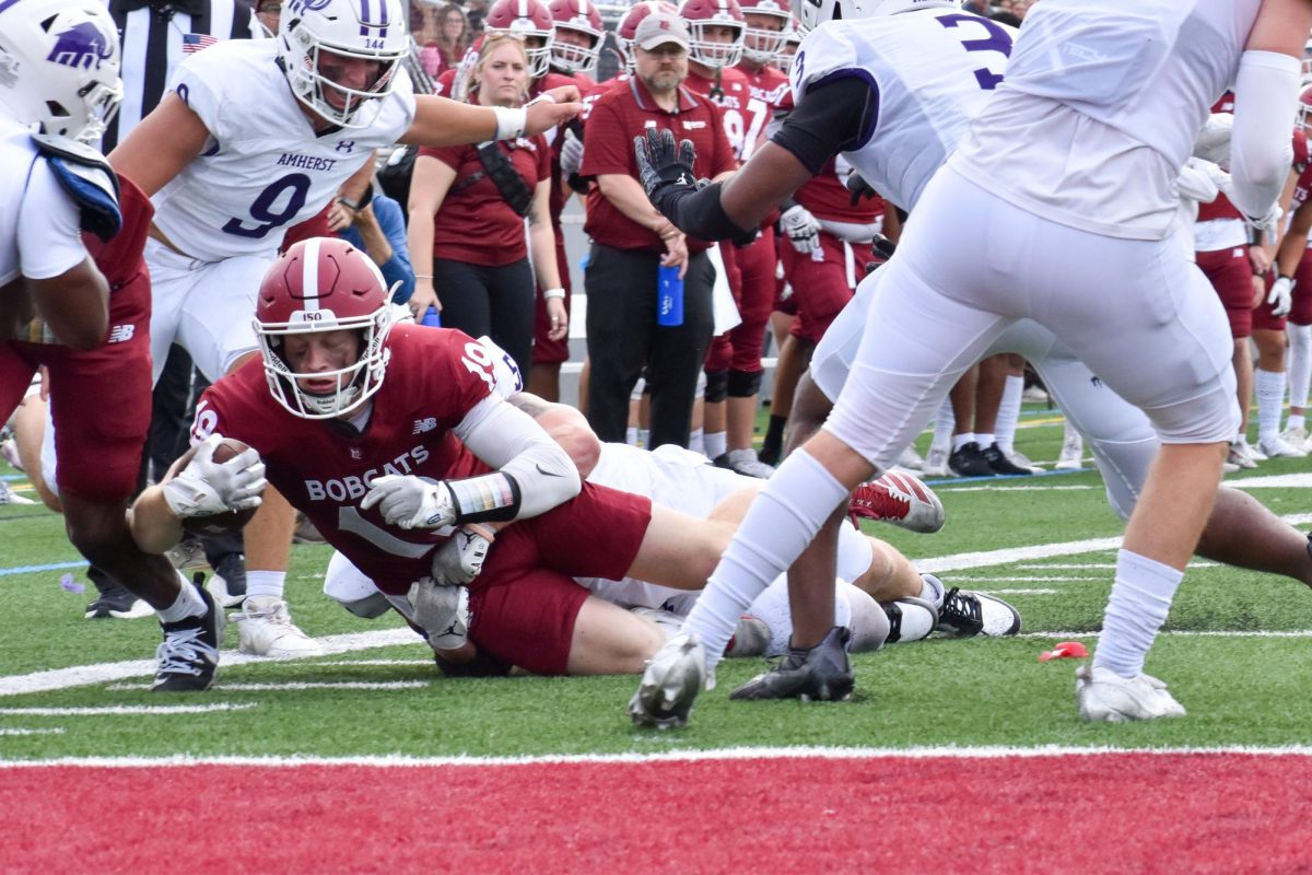 Matthew Holmes '26 securing the ball in his hand while getting closer to the end-zone on Garcelon Field.