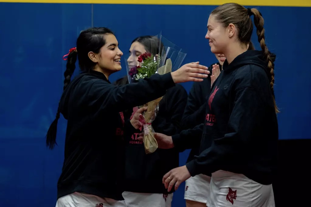 Aasya Patel '26 hugs teammate Sav Thomson '28 during the squash team's senior night. 