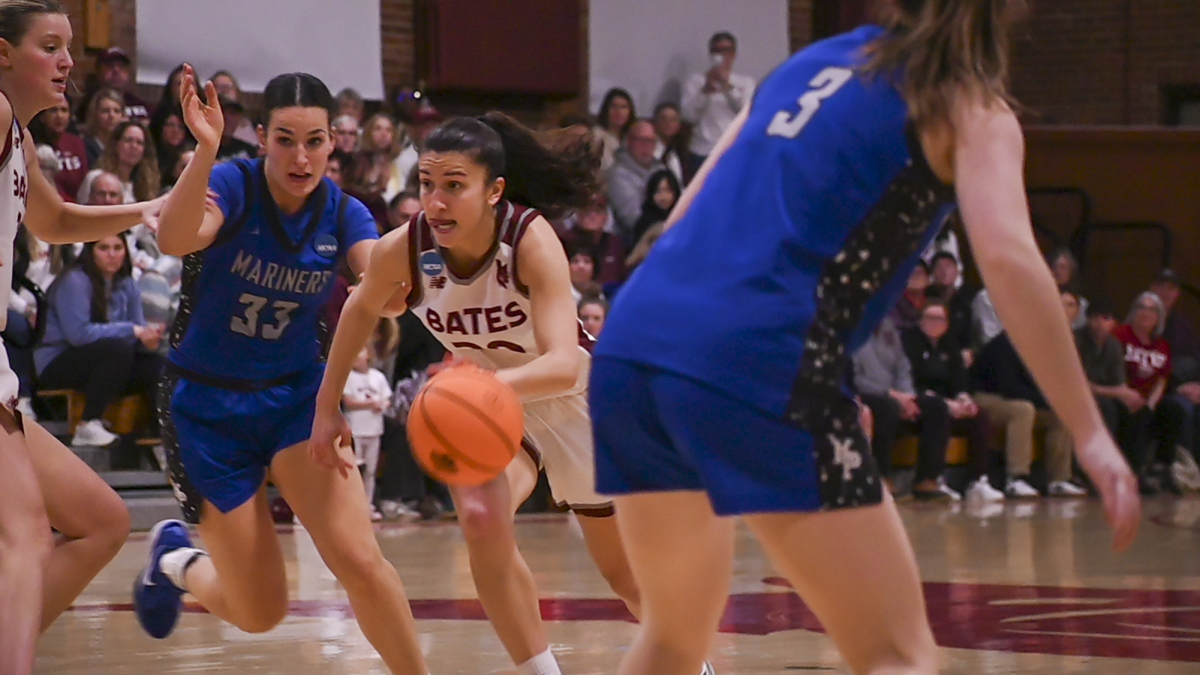 Ava James' 26 dribbling between two players of Merchant Marine Academy.