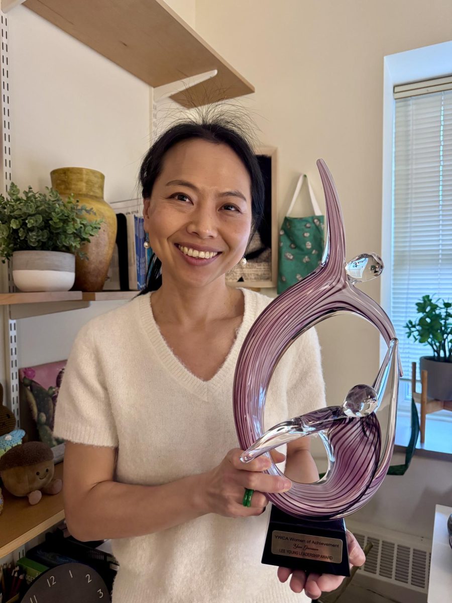 Assistant Professor of Psychology Yun Garrison stands with her Lee Young Leadership Award from the YWCA. 