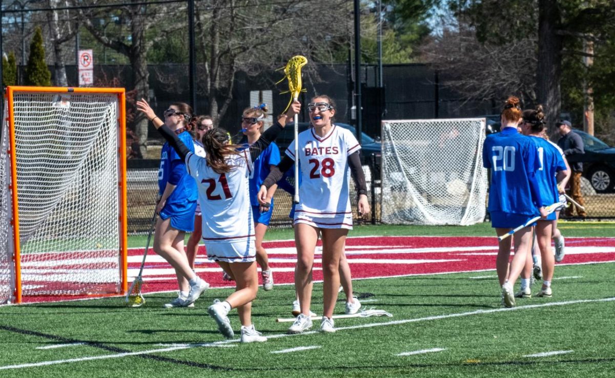 Lauren Wong '26 and Caroline Keating '26 celebrate a goal in the Bates vs. Hamilton game.